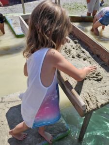 Mini schürft im Sand
