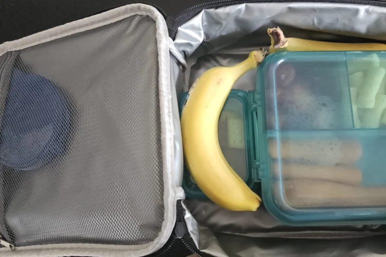 Snacks und Getränke in Brotdosen und Bananen in einer kleinen Kühltasche für den Familien-Roadtrip.