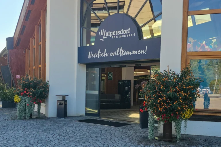 Haupteingang Therme Loipersdorf mit Willkommen-Schild und Blumenschmuck