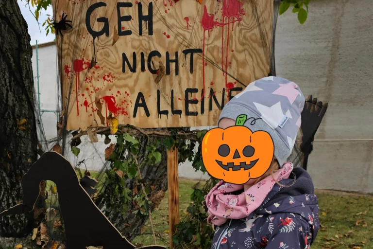 Kind beim Halloween-Ausflug auf Schloss Hof vor einem Gruselschild – perfekter Familienmoment
