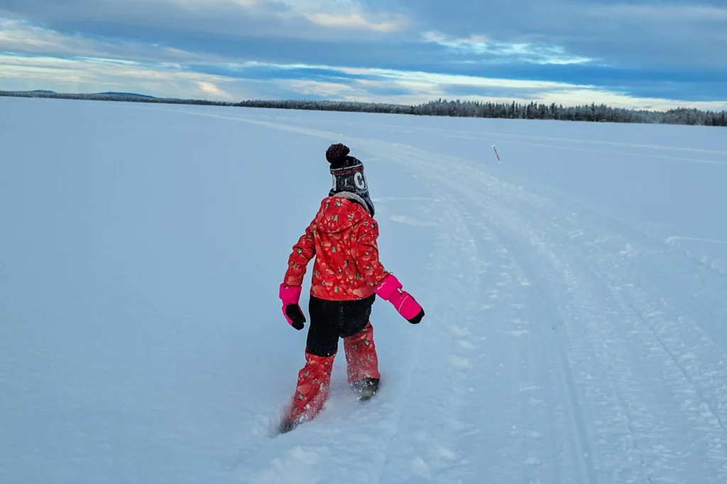 Kind in kompletter Skikleidung bei -20 Grad im Schnee in Lappland – Beispiel für funktionierendes Schichtsystem