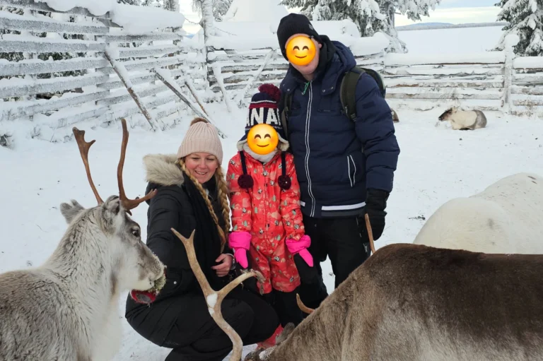 Familie auf einer Rentierfarm in Levi in Lappland im Winter zwischen Rentieren